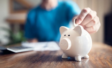 Man puts coin into piggy bank